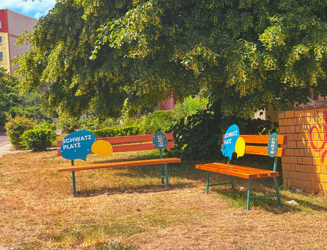 zwei freundlich gestaltete Bänke stehen über Eck und bilden einen Schwatzplatz im Quartier Regenstein.